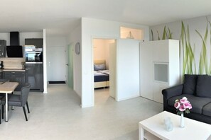 Ein stilvoller Wohnraum mit Essbereich, Küchenzeile und Schlafzimmer.