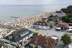 Eine Küstenstadt mit Strand, Häusern und einem Steg.
