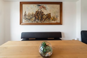 Ein Konferenzraum mit einem Holztisch, einer schwarzen Couch und einem gerahmten Gemälde von Soldaten, die eine amerikanische Flagge hissen.