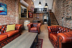 Ein gemütliches Interieur mit Ledersofas, einem Holztisch und einer Ziegelwand.