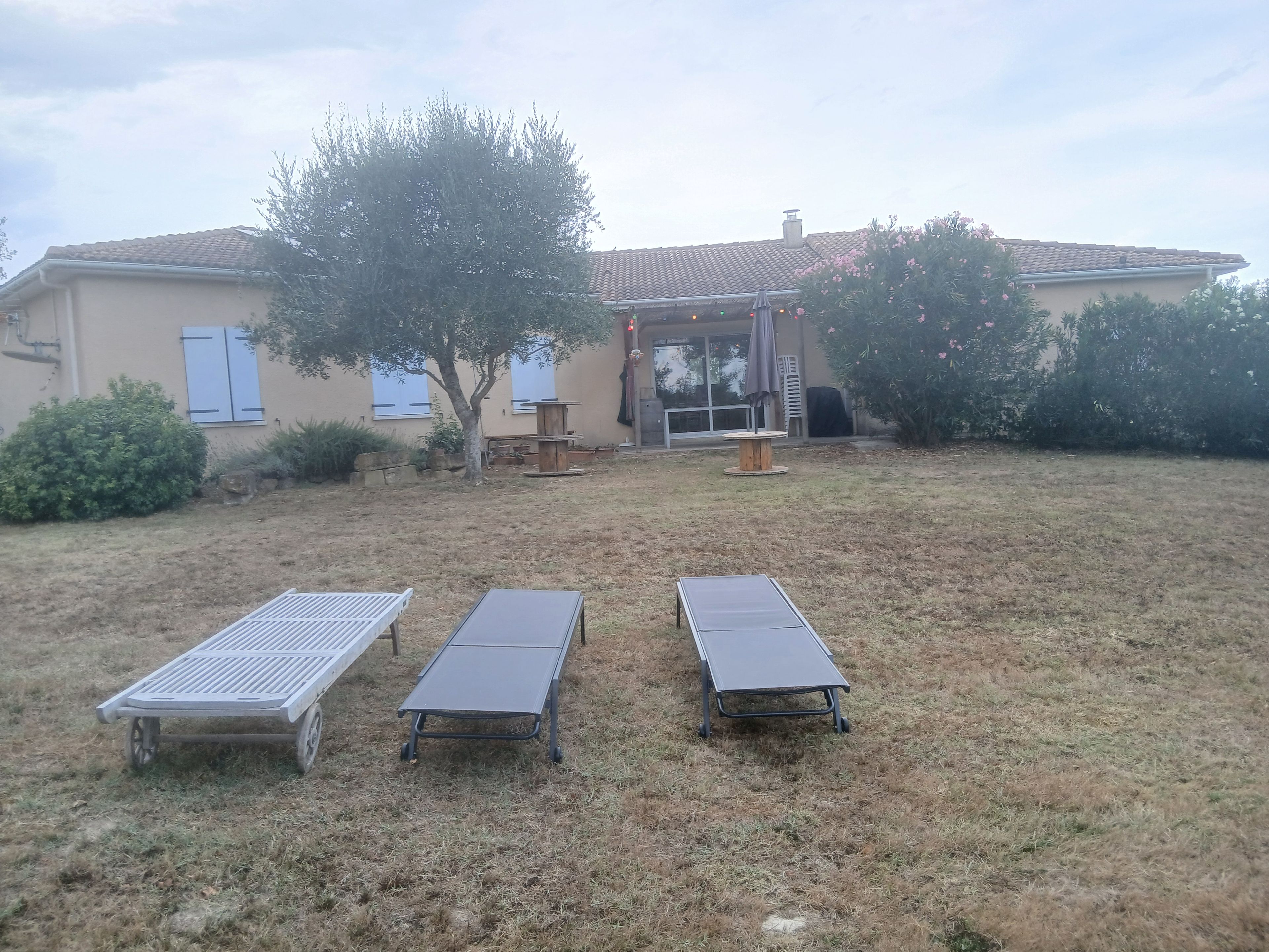 Une maison dotée d’un patio comprenant une table et deux chaises.