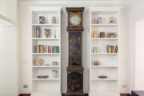 A room with two white bookshelves flanking a tall, ornately decorated column. - Bernini in Cavour (Roma)