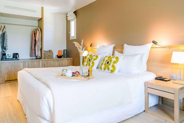 Una habitación de hotel con una cama grande, una mesita de noche y un espejo.