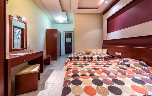 Una habitación de hotel con una cama, un escritorio, una silla y un armario.