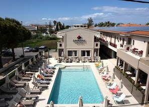 A hotel with a swimming pool, lounge chairs, and a red maple leaf logo. - Canadian Annex (Zakynthos)