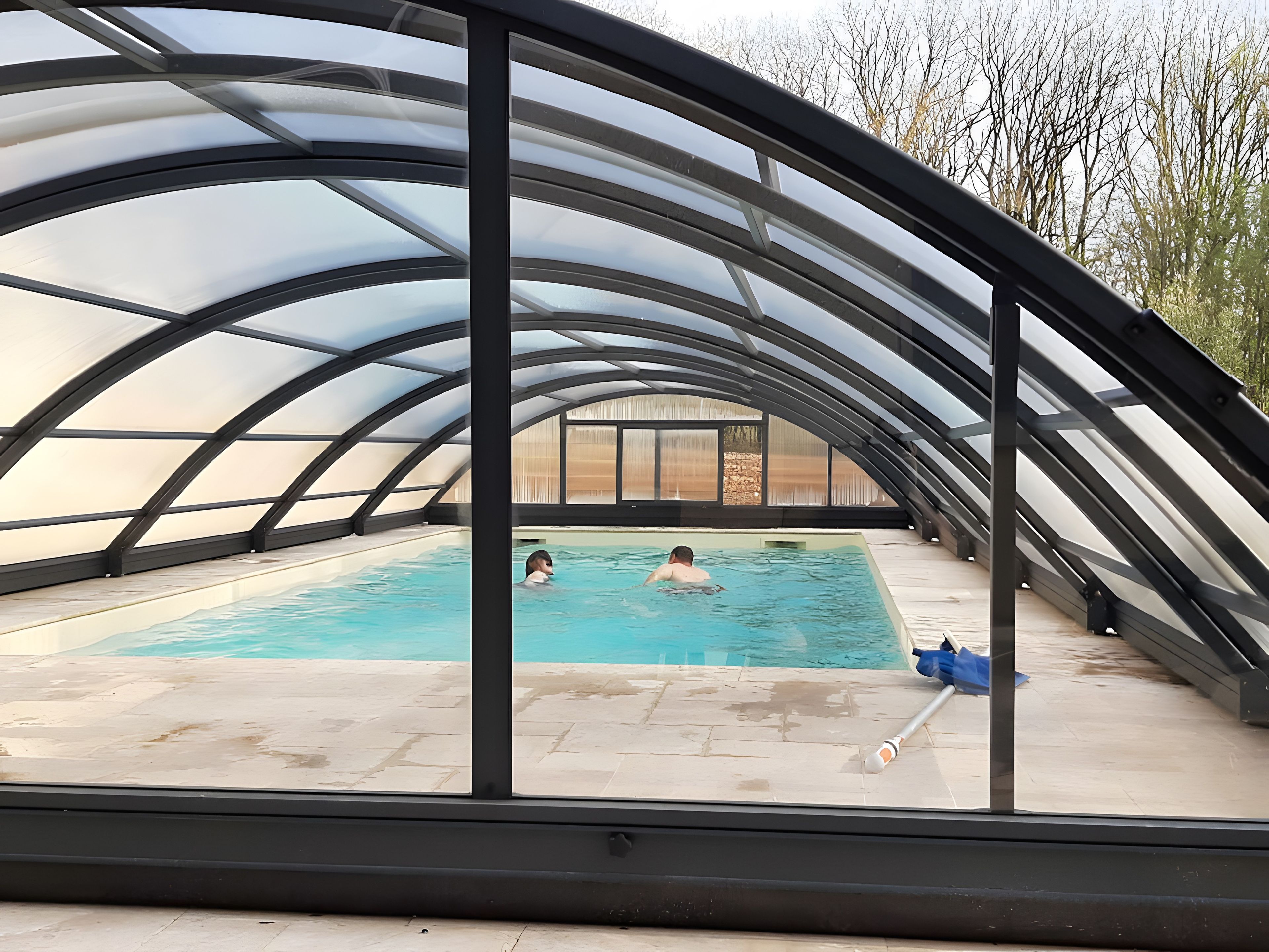 An indoor swimming pool with a curved roof structure.