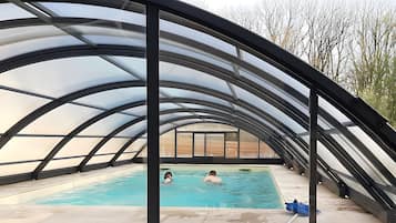 An indoor swimming pool with a curved roof structure.