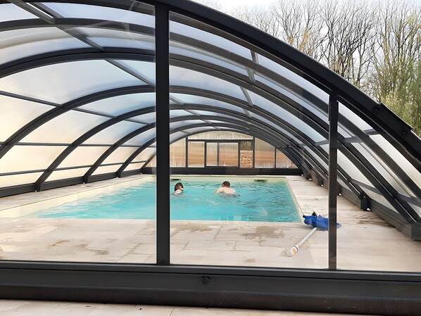 An indoor swimming pool with a curved roof structure.