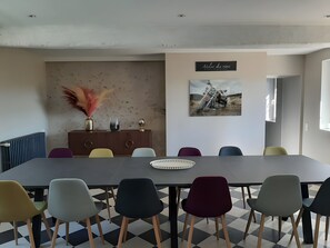 A conference room with a long table, multiple chairs, a radiator, decorative items, and a wall-mounted sign. - Holiday Home 'Gîte De La Boivinière' with Private Pool, Private Terrace and Wi-Fi (Autrèche)