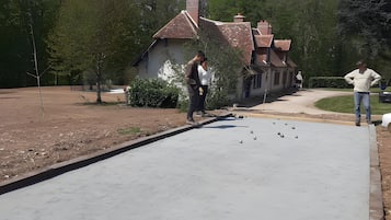 A paved pathway leading to a building with a red roof.