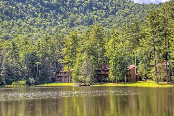 A lodge with multiple buildings surrounded by a forest and a lake. - Foxhunt At Sapphire Valley (Sapphire)