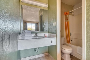 A bathroom with a sink, mirror, and toilet. - Hotel Tucson Downtown (Tucson)