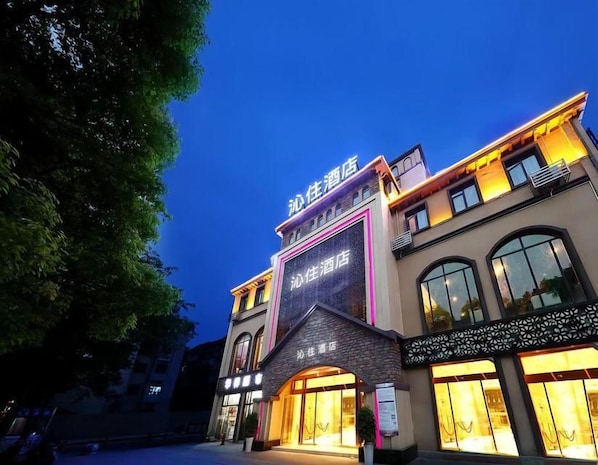 A hotel with a prominent sign, large windows, and a well-lit entrance. - Lavande Hotel (Guiyang)