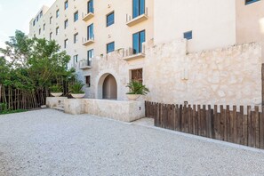 Ein mehrstöckiges Gebäude mit Steinaußenseite, Holzzaun und Kieshof.