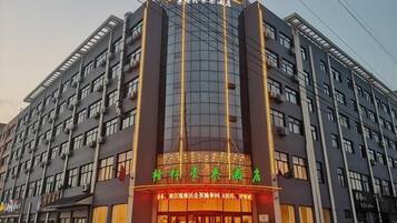 A multi-story hotel with a prominent entrance, large windows, and a sign indicating it is a hotel.