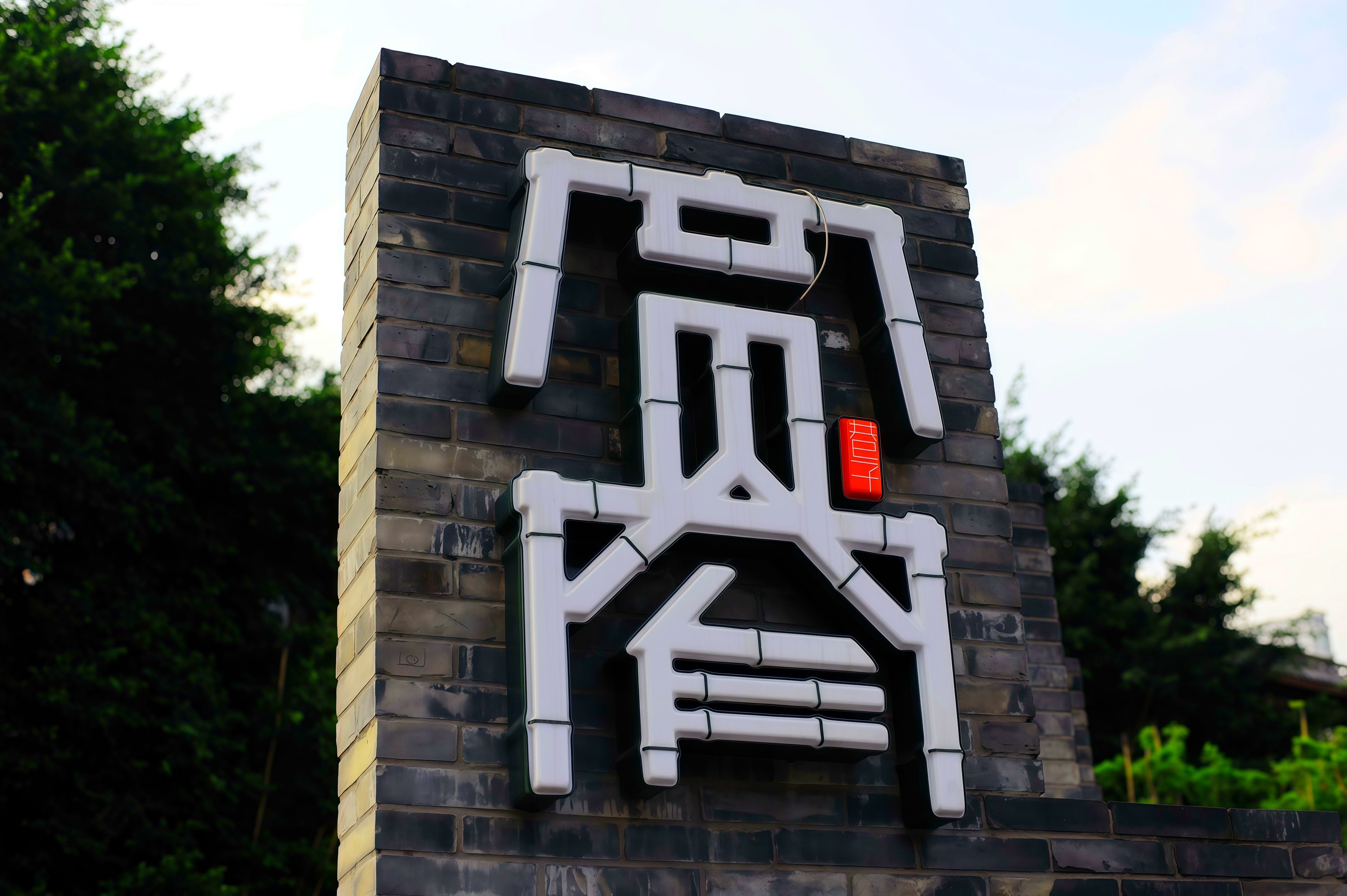 A building with a modern facade featuring a large, stylized sign with Chinese characters.