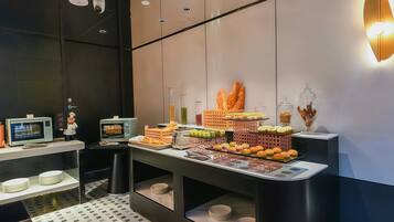 A modern kitchen area with a microwave, toaster, and a variety of food items displayed on a counter.