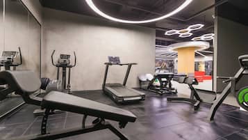 A modern gym with various exercise equipment, including treadmills and weight machines.