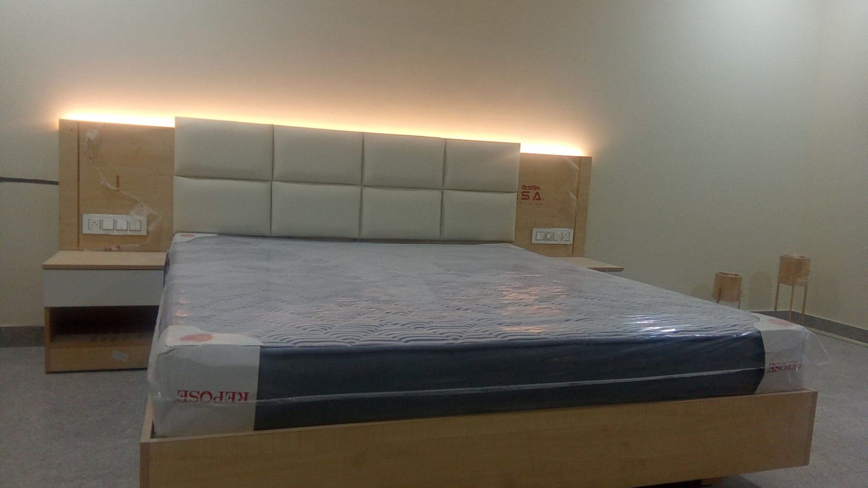 Una camera da letto con un letto, testiera, comodini e materasso.