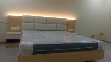 Una camera da letto con un letto, testiera, comodini e materasso.