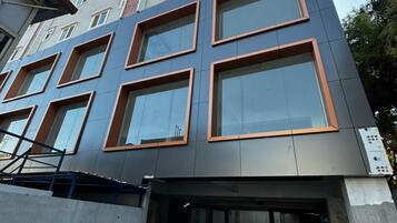 A multi-story building with a mix of window styles and a construction area with tools and materials.