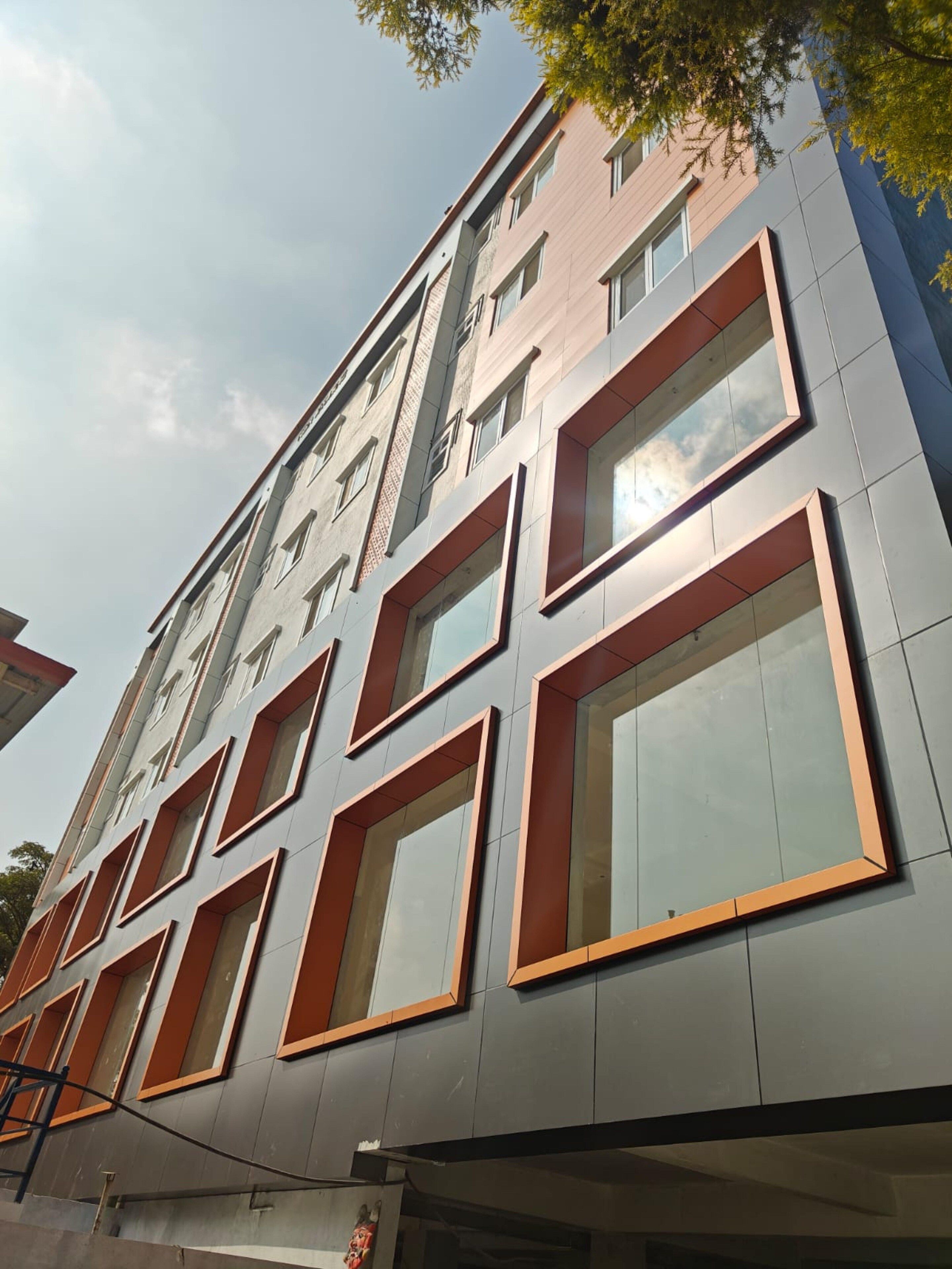 A multi-story building with a modern architectural design, featuring large windows and a mix of rectangular and square shapes.