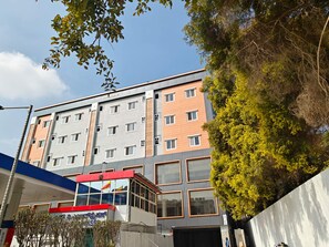 Un hotel a più piani con facciata moderna, numerose finestre e un ingresso ben visibile con un cartello.