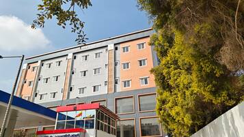 Un hotel a più piani con facciata moderna, numerose finestre e un ingresso ben visibile con un cartello.