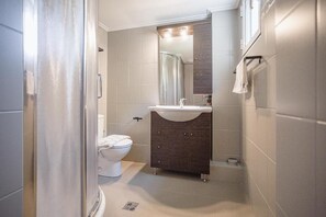 Un baño con inodoro, lavamanos y espejo.