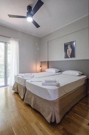 Una habitación de hotel con una cama, un ventilador de techo, una ventana y un cartel en la pared.