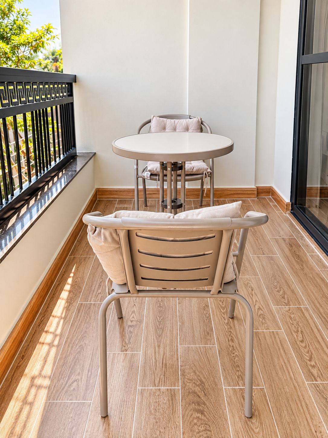 Ein Balkon mit rundem Tisch und Stühlen, einer gepolsterten Bank und Blick ins Freie.