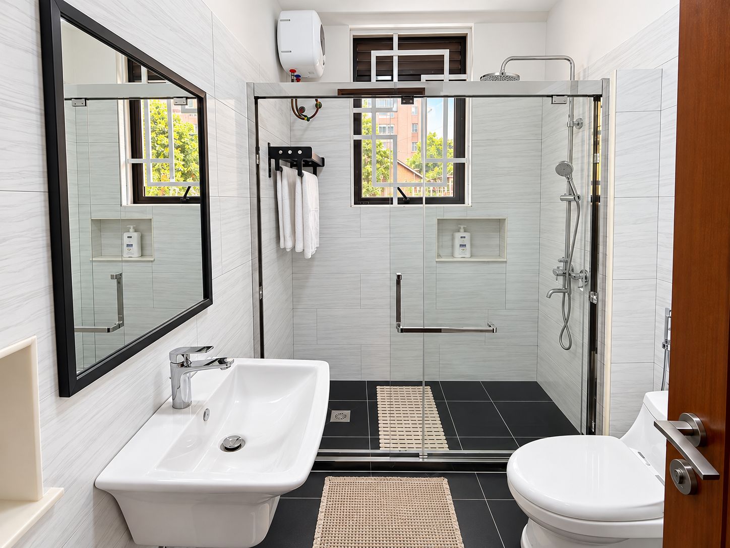 A modern bathroom with a glass-enclosed shower, a white sink, and a toilet.