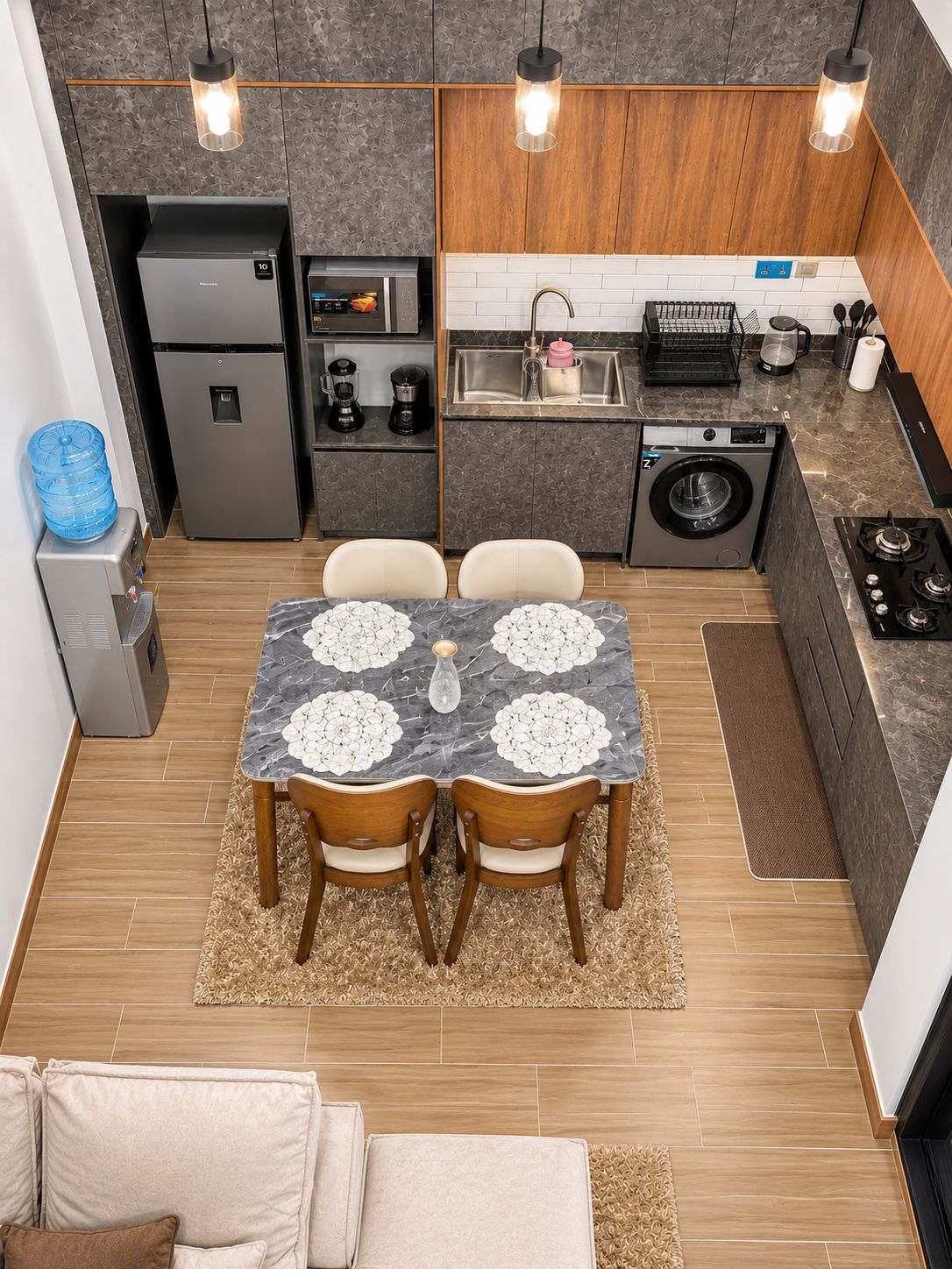 A compact kitchen with a dining area, including a refrigerator, coffee maker, and washing machine.