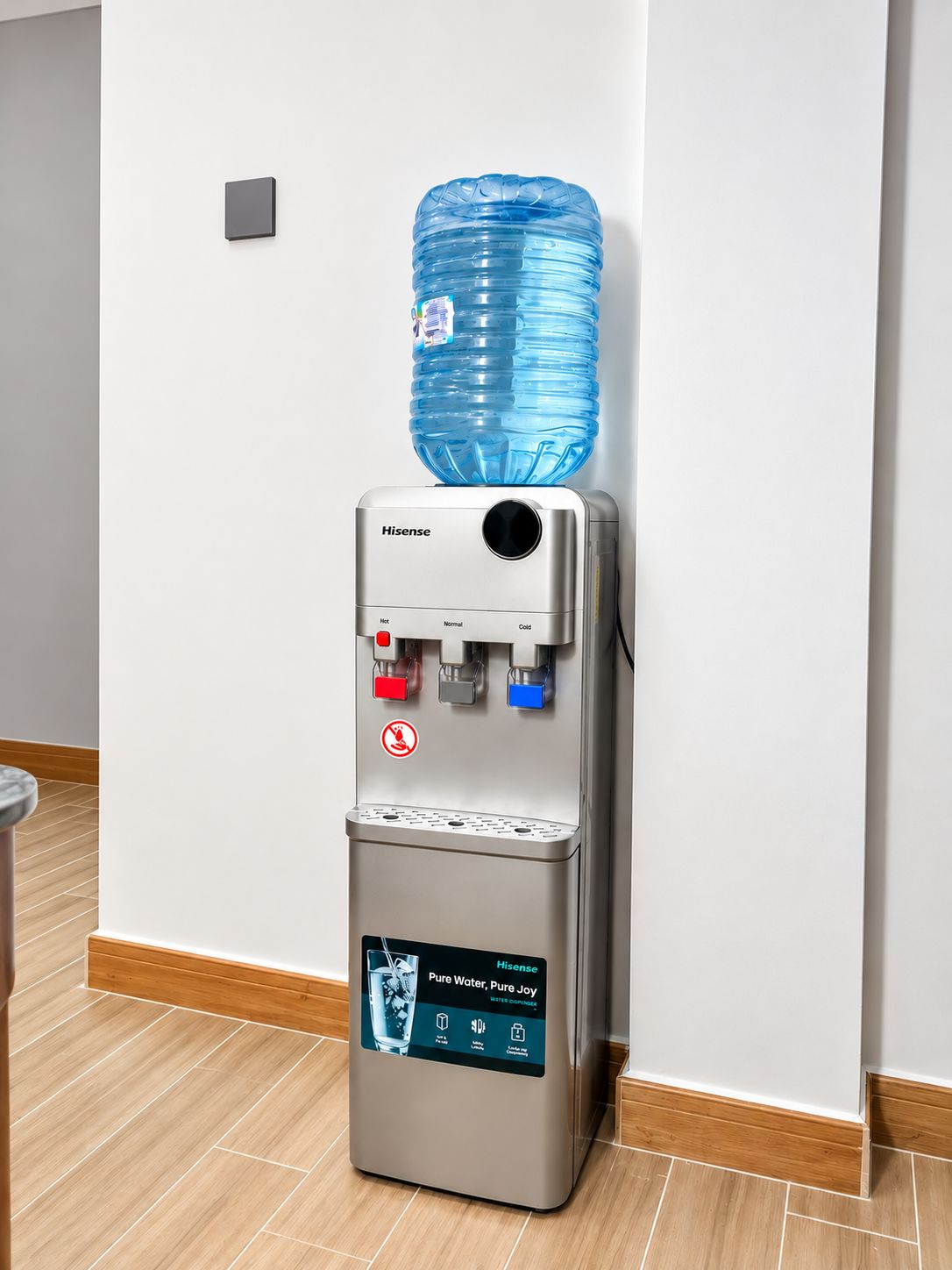 A water dispenser with a large water bottle on top, a control panel with temperature settings, and a sign indicating no smoking.
