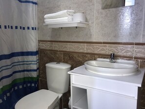 A bathroom with a toilet, sink, and a towel rack. - Ayenda The Mendoza Grand 1326 (Barranquilla)