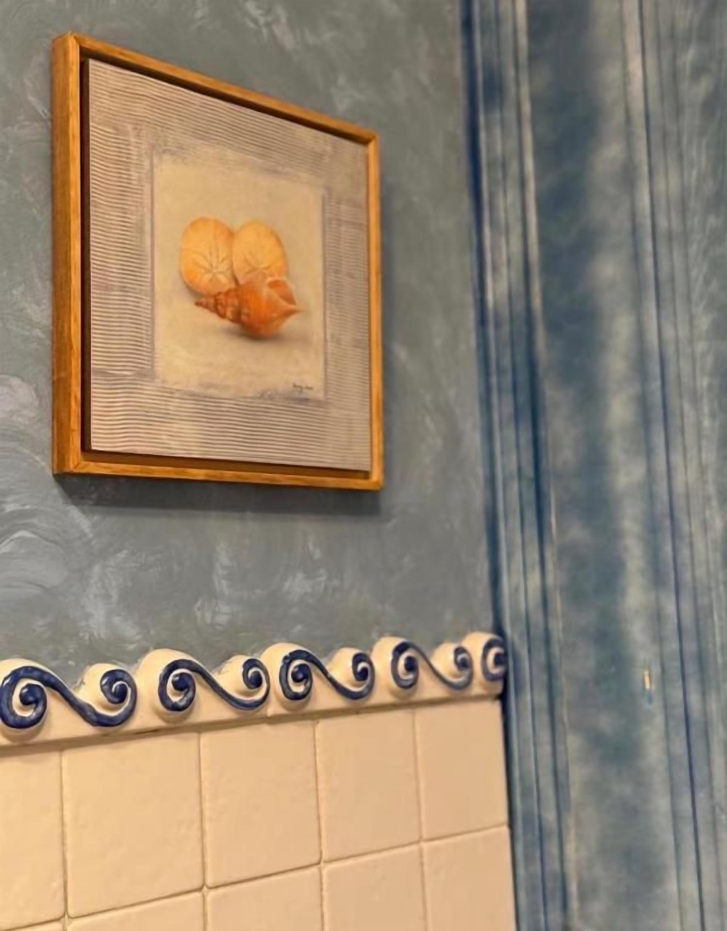 Una fotografía enmarco de una concha marina sobre una pared con textura.