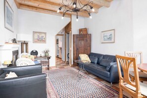 A cozy living room with a sofa, chairs, a coffee table, and a patterned rug. - Charming house with patio near Lake Lugano (Magliaso)