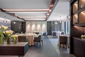 A modern dining area with round tables, chairs, and a central bar area. - The G Shenzhen, A Tribute Portfolio Hotel (Shenzhen)