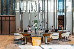 Una sala de conferències moderna amb una illa central, quatre cadires i dos portàtils damunt l'illa.