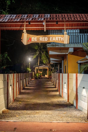 A pathway leading to a building with a sign reading 'DE RED EARTH'. - De Red Earth (Arambol)