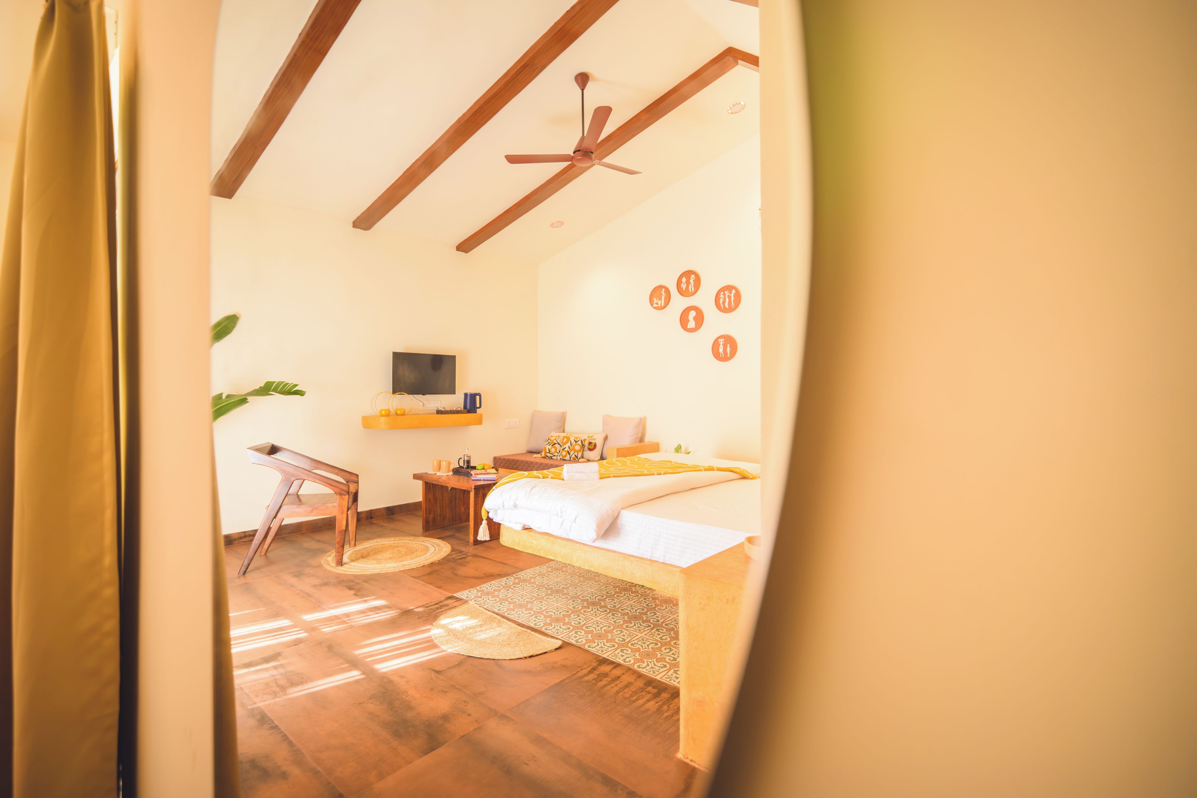 A room with a bed, a desk, a chair, a television, and a ceiling fan.
