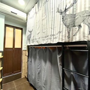 A room with a striped curtain, a wooden door, and a tiled floor. - Royal Paris Guesthouse (Kowloon)