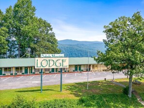 A motel named 'Saluda Mountain Lodge' with a parking lot and a view of distant mountains. - Early Blue Motel (Saluda)