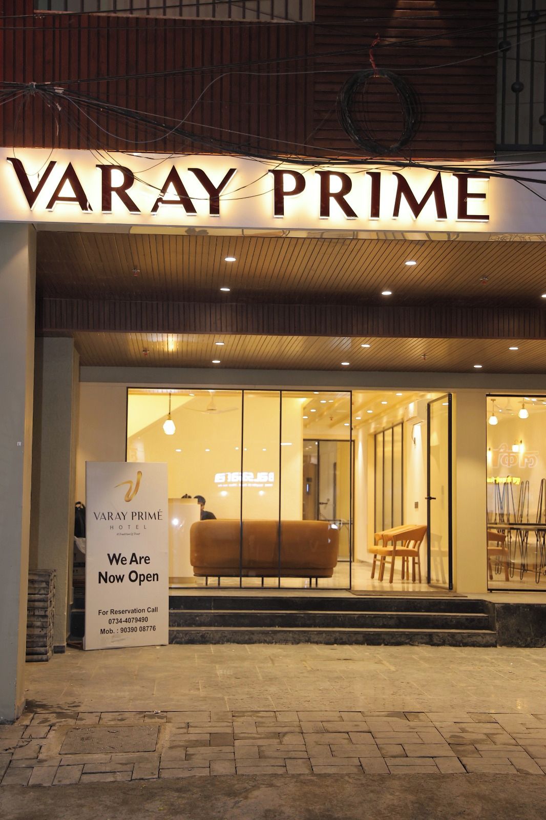 Fasaden på Varay Prime Hotel, med en skylt som visar att hotellet nu är öppet.