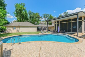 A backyard with a swimming pool, a covered patio, and a house. - Experience resort style luxury at the stylish Houston property with a private pool. Minutes from the city's top dining and shopping. (Houston)
