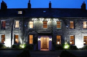 A stone building with the name 'Collingwood Arms' illuminated at night. - Collingwood Arms Hotel (Cornhill on Tweed)