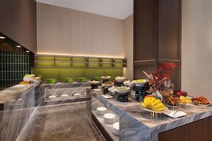 A buffet setup with various food items and a marble counter. - Days Hotel by Wyndham Suzhou Dushu Lake (Suzhou)