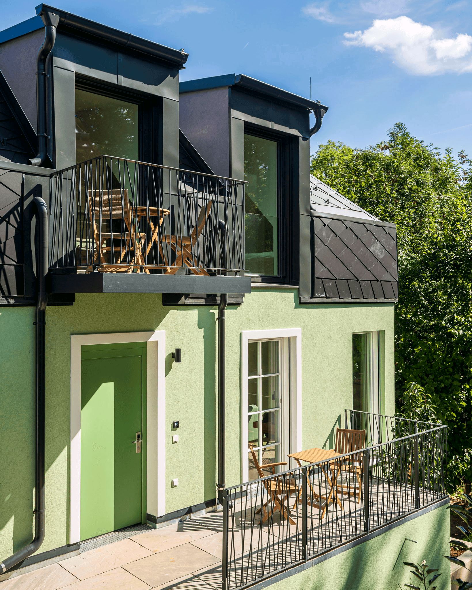 Ein modernes, zweistöckiges Gebäude mit Balkon, Tür und Fenster.
