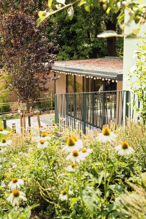 A garden with a wooden structure, surrounded by various plants and flowers. - Das Winzer (Wien)