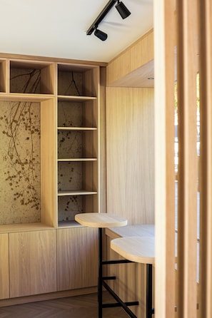 A room with wooden shelving units, a small table, and a ceiling light fixture.